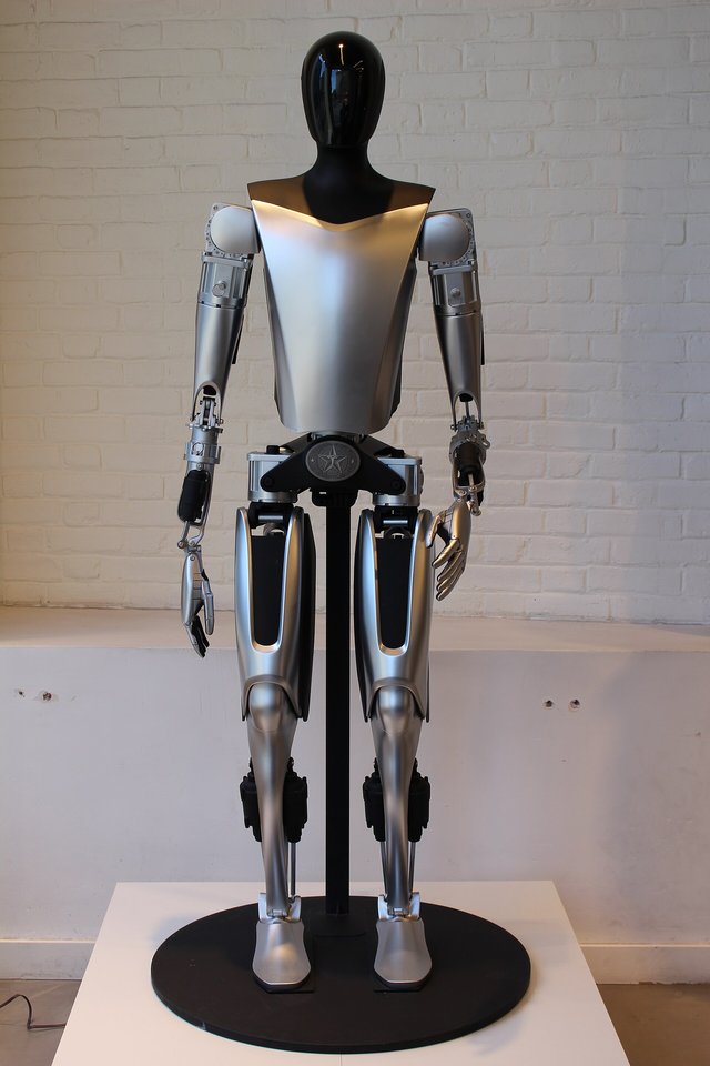 Tesla Optimus – humanoider Roboter Humanoider Roboter Tesla Optimus auf einem Ausstellungssockel